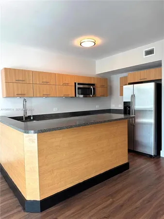 a view of kitchen with kitchen island a sink and a counter top