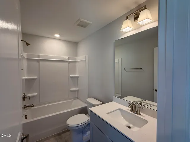 a spacious bathroom with a double vanity sink mirror and bathtub