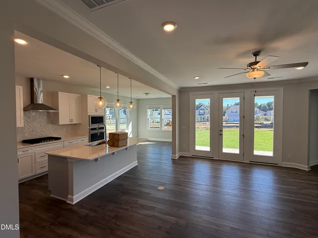 a large white kitchen with large windows and refrigerator
