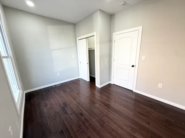 an empty room with wooden floor and closet