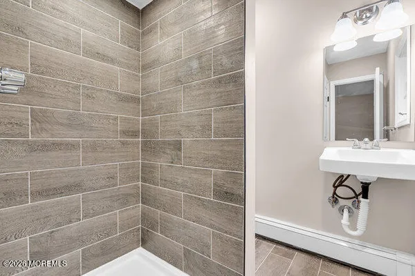 a bathroom with a sink a shower and a mirror