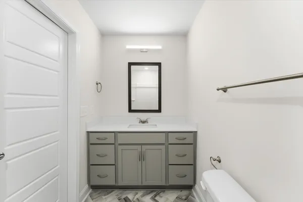 a bathroom with a toilet a sink and mirror