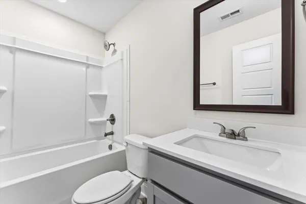 a bathroom with a sink toilet vanity and shower