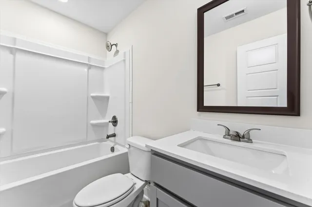 a bathroom with a sink toilet vanity and shower