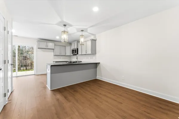 a view of kitchen with granite countertop cabinets and wooden floor