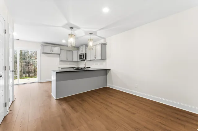 a view of kitchen with granite countertop cabinets and wooden floor