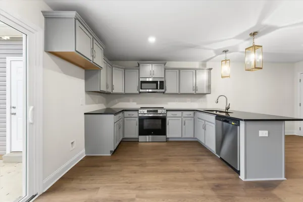 a kitchen with granite countertop a stove top oven sink and cabinets