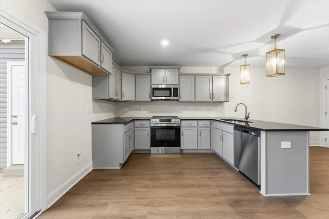 a kitchen with granite countertop a stove top oven sink and cabinets
