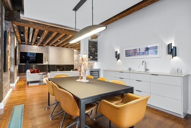 a kitchen with a table chairs and wooden floor