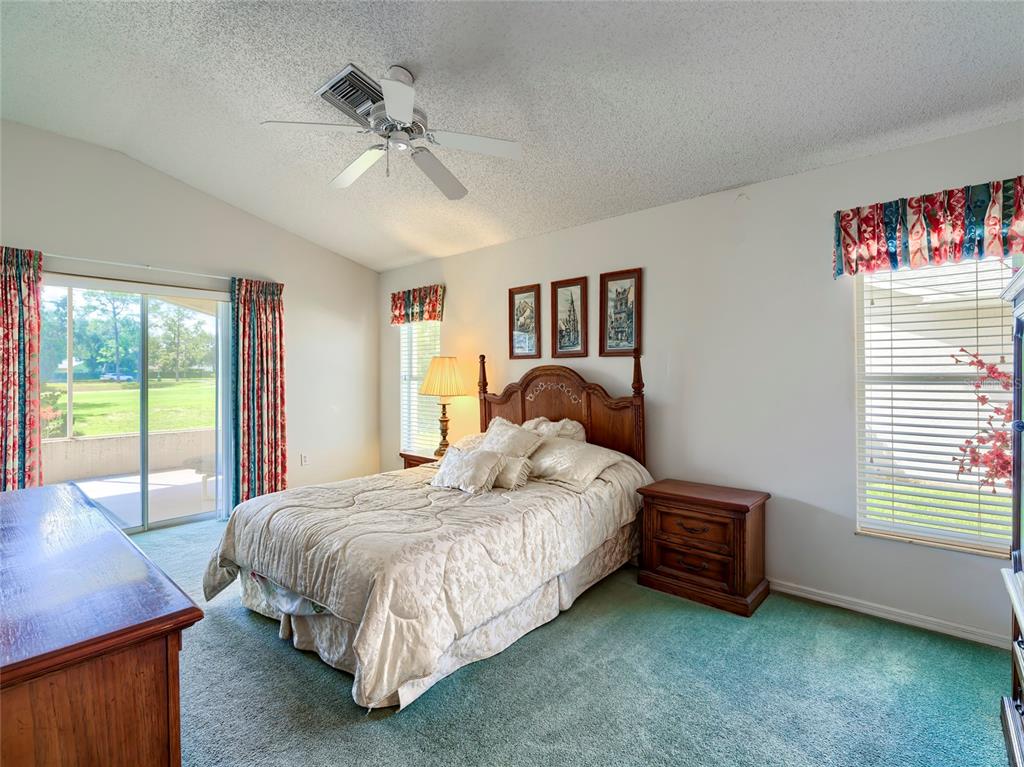 11228 Windrush Circle Hudson, FL 34667 - Photo 29 of 67 a bedroom with a bed and a chandelier
