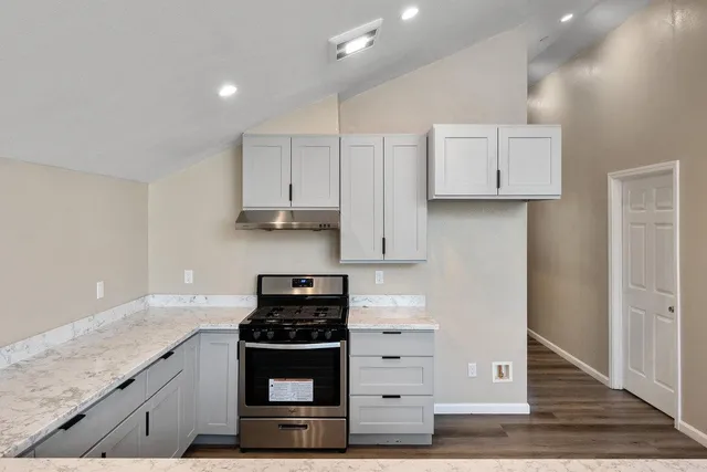 a kitchen with stainless steel appliances granite countertop a stove and a refrigerator