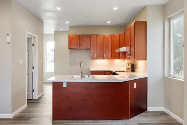 a kitchen with stainless steel appliances granite countertop a sink stove and refrigerator