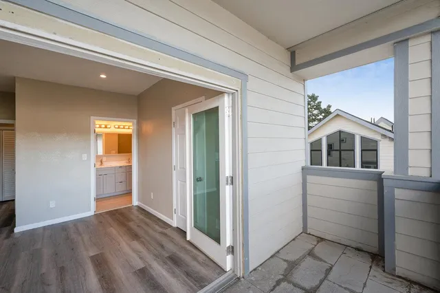 a view of a hallway with entryway and wooden floor