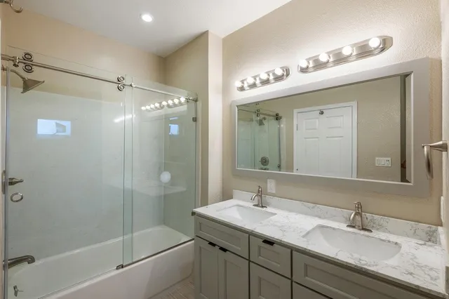 a bathroom with a granite countertop sink a shower and a mirror