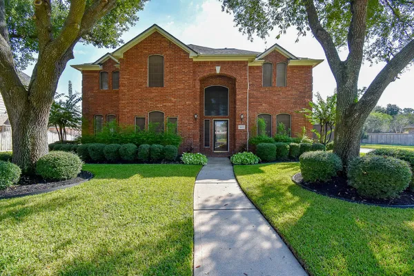 a front view of a house with yard and green space