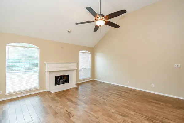 wooden floor fireplace and windows in an empty room