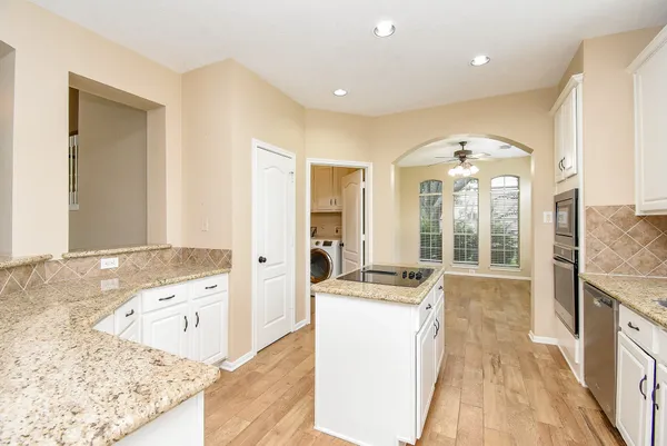 a view of a kitchen island a sink wooden floor and a living room