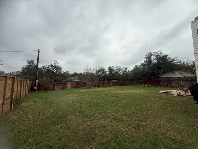 a view of a big house with a big yard and large trees