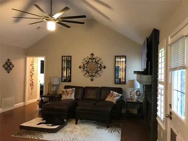 a living room with furniture ceiling fan and a window