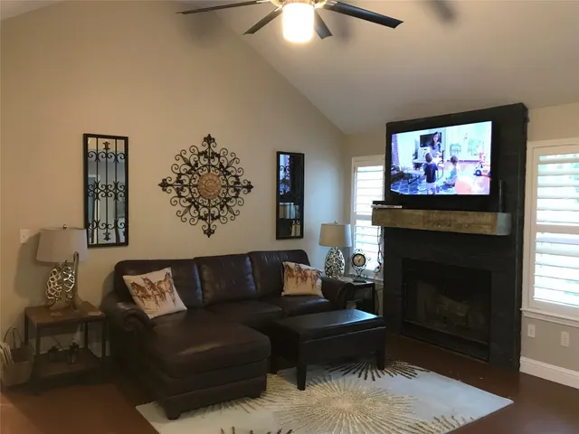 a living room with furniture a flat screen tv and a fireplace