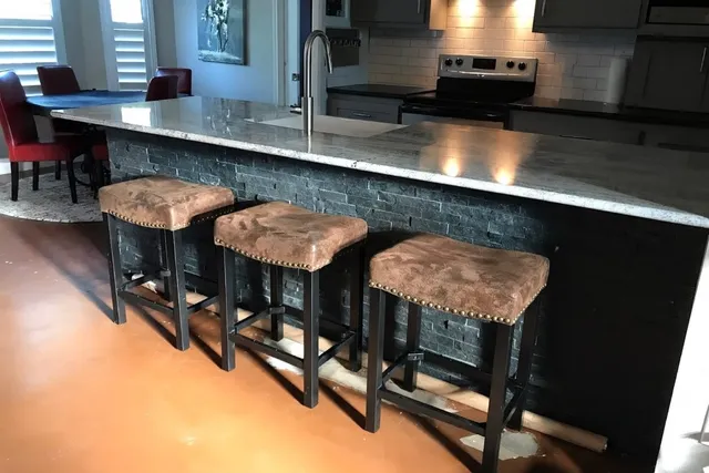 a kitchen with stainless steel appliances a sink a table and chairs in it