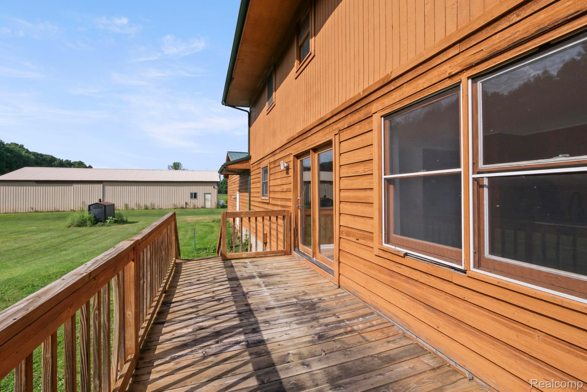 76565 McFadden Road Armada, MI 48005 - Photo 49 of 95 Wood deck with railing, siding exterior, multiple windows, and a detached outbuilding