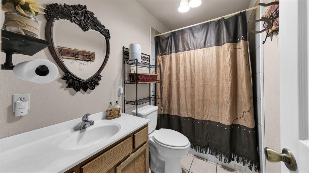 11500 Bowden Road Lipan, TX 76462 - Photo 25 of 32 Bathroom with tile patterned floors, toilet, and vanity