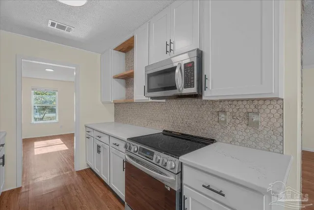 a kitchen with stainless steel appliances a stove microwave and cabinets