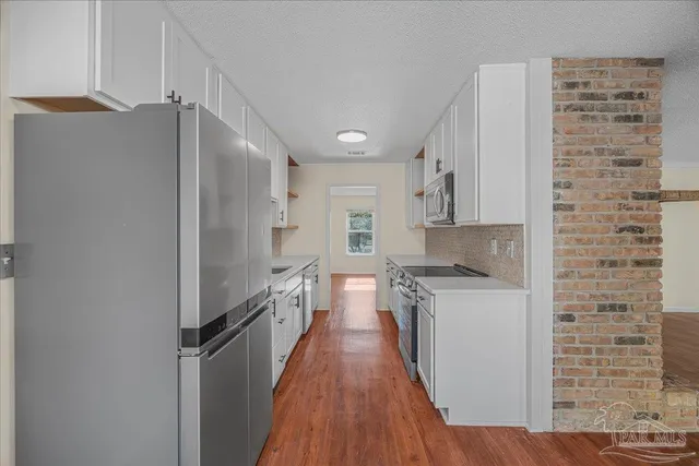 a kitchen with stainless steel appliances a refrigerator and a stove