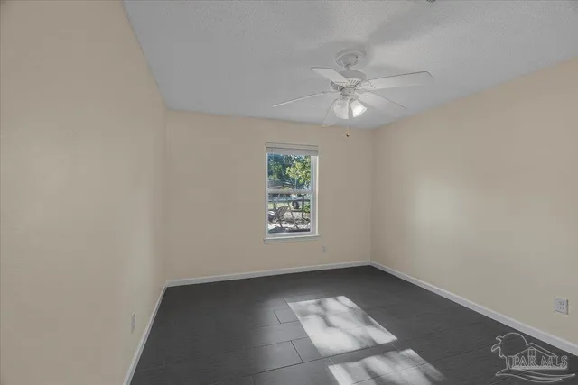 an empty room with a ceiling fan and a window