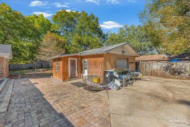a view of a chair and table in the back yard of the house