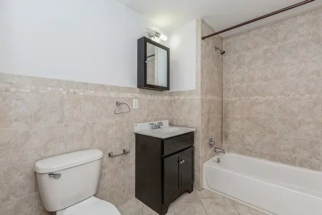 a bathroom with a toilet sink vanity tub and shower