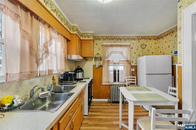 a kitchen with sink a refrigerator and chairs