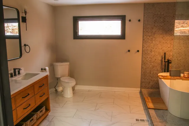 a bathroom with a toilet a sink and mirror
