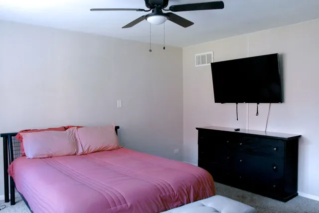 a bedroom with a bed and a flat screen tv