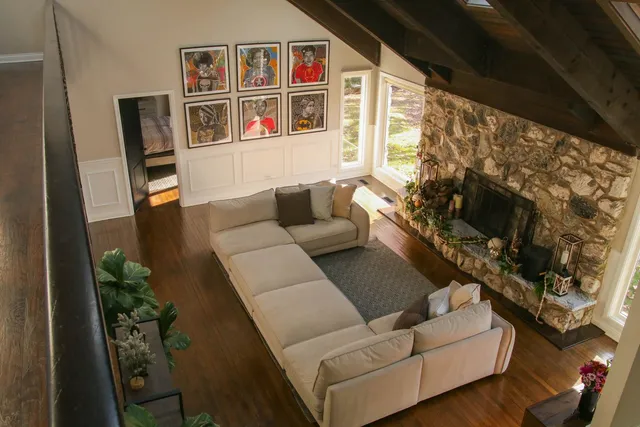 a living room with furniture a flat screen tv and a floor to ceiling window