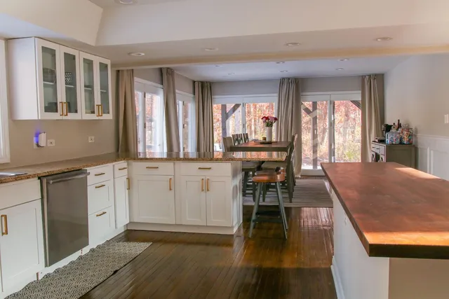 a view of a kitchen with kitchen island granite countertop wooden floor and a window