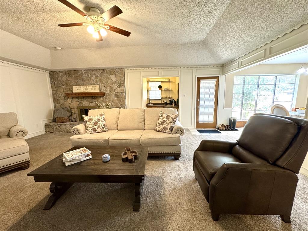 113 Northeast Timber Ridge Drive Burleson, TX 76028 - Photo 10 of 36 Stone fireplace with a wood mantel, Wet Bar, and Vaulted Ceiling. Nice carpeting too!