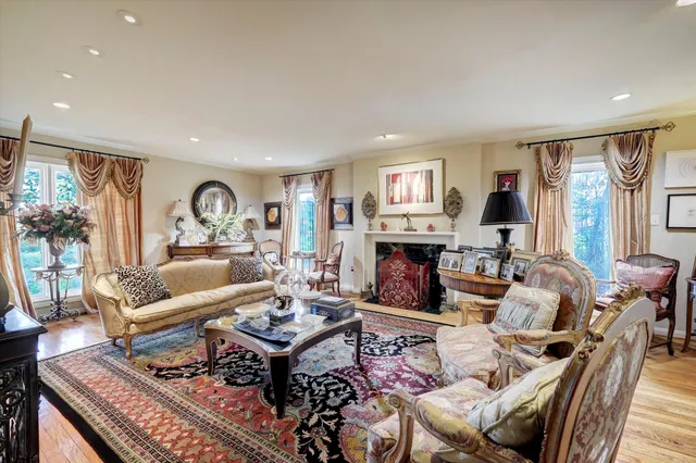 a living room with fireplace furniture and a large window