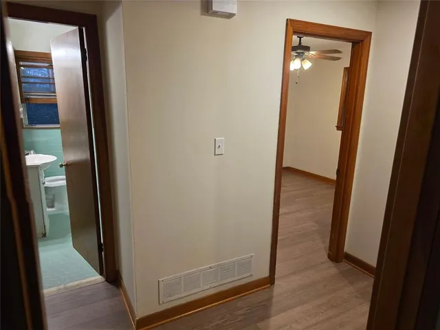an empty room with wooden floor closet and windows