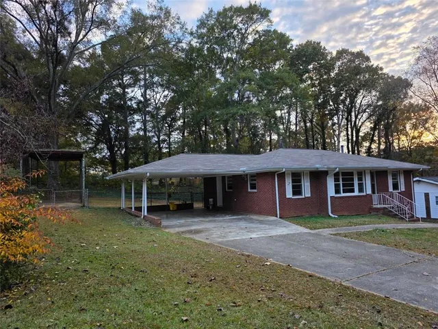 a view of a house with a yard and large tree