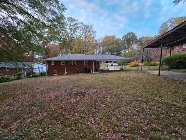 a view of a house with a yard and sitting area