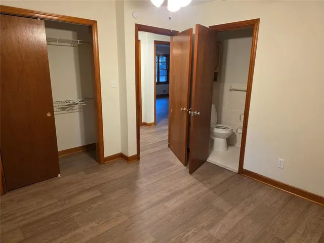an empty room with wooden floor and entrance