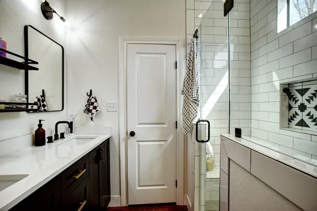 a bathroom with a granite countertop sink a potted plant and a shower