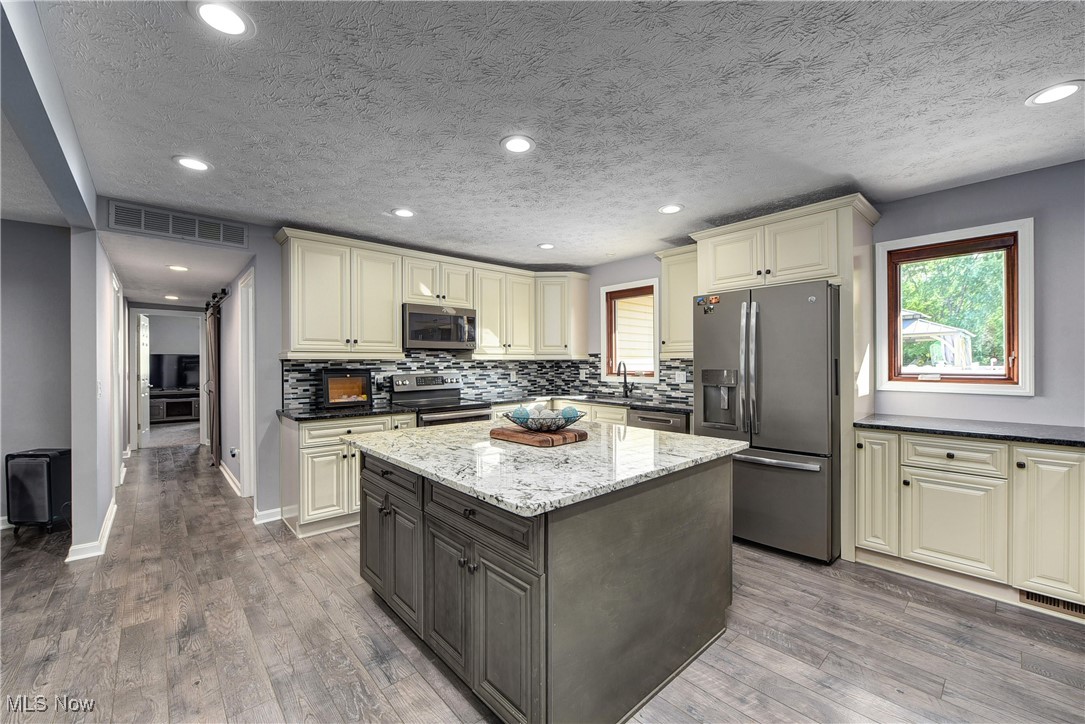 49 North Carpenter Road Brunswick, OH 44212 - Photo 8 of 39 Kitchen featuring stainless steel appliances, cream cabinets, and hardwood / wood-style floors