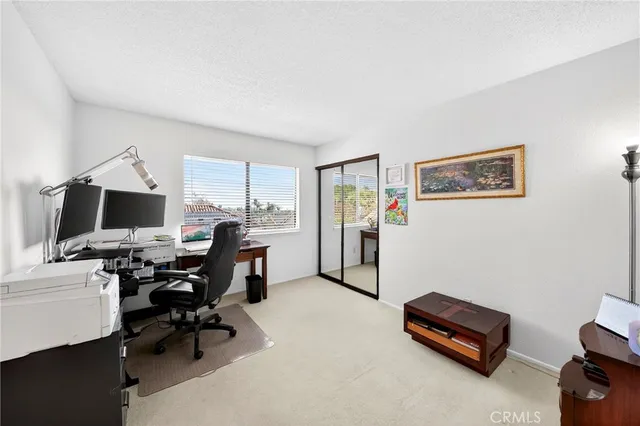 a view of a workspace with furniture and a window