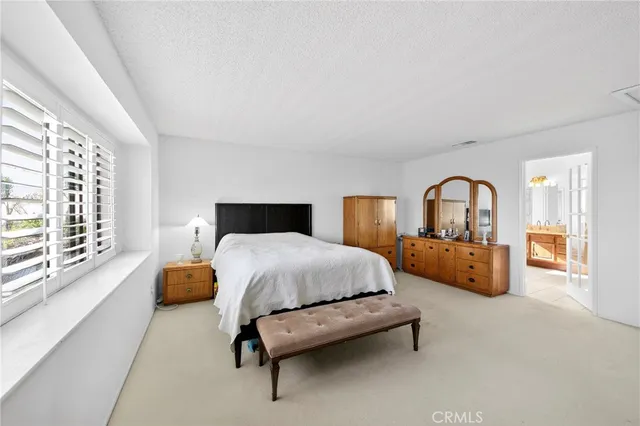 a bedroom with bed and a large window