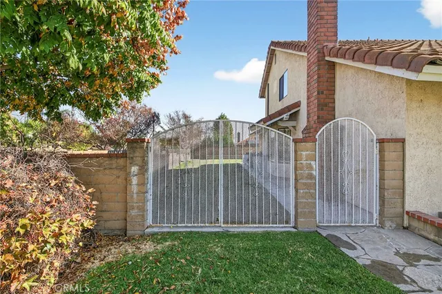 a backyard of a house with lots of green space and wooden fence