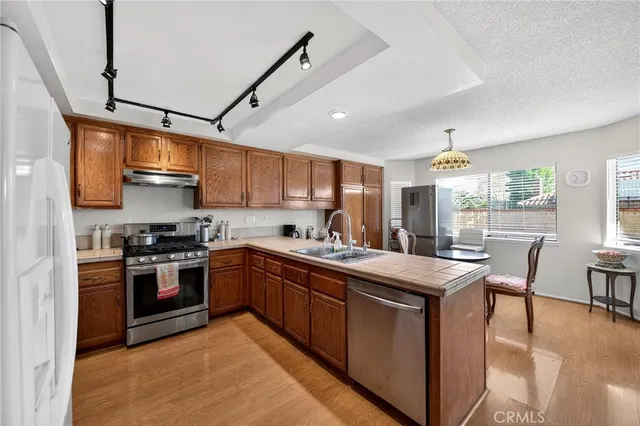 a kitchen with stainless steel appliances granite countertop a stove sink and cabinets