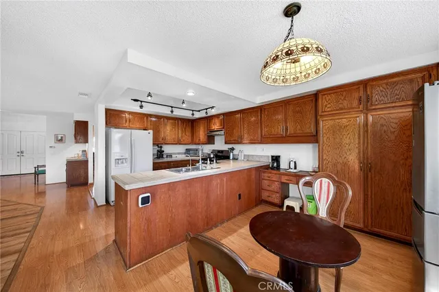 a kitchen with stainless steel appliances granite countertop a sink refrigerator stove and microwave